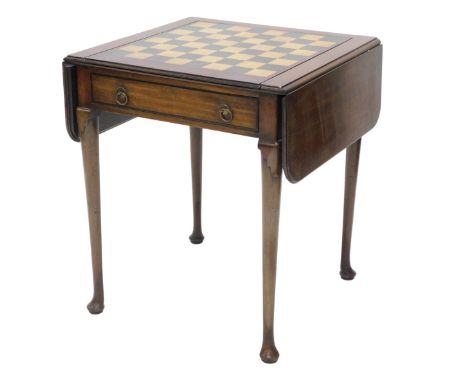 A mahogany drop leaf games table, the rectangular top with reversible lid for chess board, enclosing an interior inlaid for b