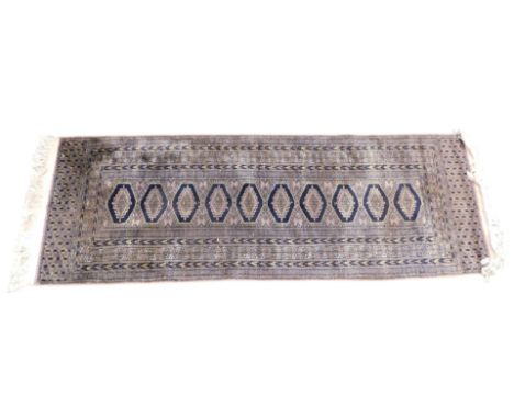 An Afghan type runner, with a design of medallions, on a multicoloured ground, one wide and various narrow borders.