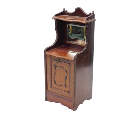 A late Victorian walnut coal purdonium, the top with a serpentine shaped shelf above a bevelled glass door, the base with a p
