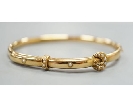 An Edwardian 15ct gold and seed pearl set hinged bracelet, interior diameter 58mm, gross weight 8.3 grams.