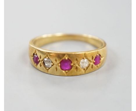 An early 20th century yellow metal and gypsy set three ruby and two stone diamond ring, size P, gross 4.3 grams.