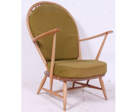 An Ercol beech and elm wood light tall back Windsor country armchair with squab cushions being raised on turned legs with tal