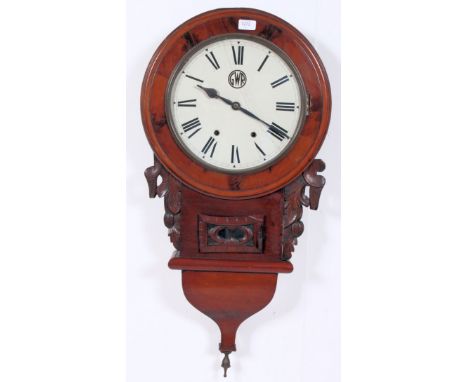 An early 20th century mahogany cased station clock. The flame mahogany trunk with glass door to lower centre with brass pendu