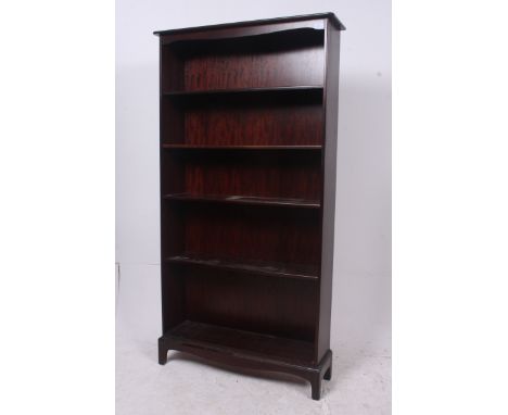 A large Stag mahogany minstrel library bookcase cabinet having bracket feet with an upright body having central shelves. Meas