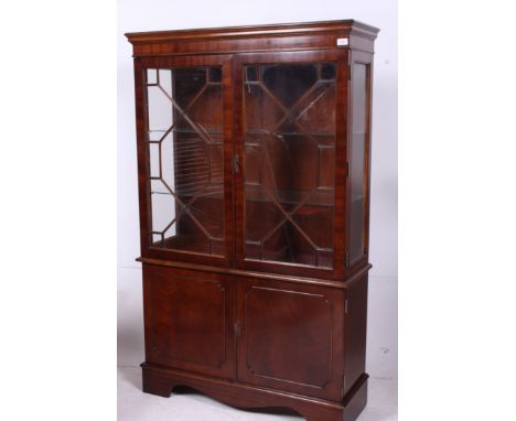 A good quality mahogany display cabinet having astragal glazed doors with flared top being raised on bracket feet