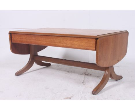 A 1970's retro Nathan drop leaf sofa style coffee occasional table raised on sabre style supports with drop leaves either end