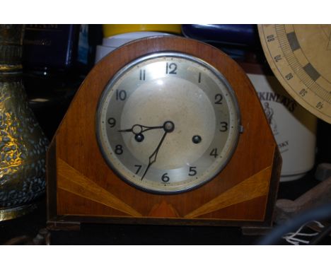 An Art Deco mahogany inlaid mantel clock with brass movement.