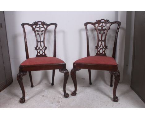 A pair of early 20th century mahogany Chippendale dining chairs. Raised on cabriole legs with ball and claw feet with drop in