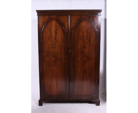 A 1940's Queen Anne walnut double wardrobe raised on bracket feet with twin full length doors having hanging space within. Fl