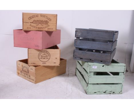 A stack of vintage 20th century  wooden crates being painted to include varying sizes along with a carpenters box being paint