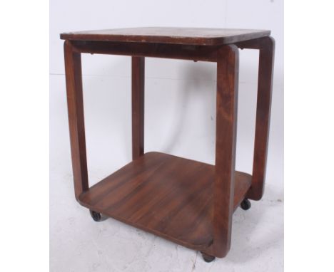 A post war 1940's Art Deco square two tier trolley table having squared supports with original castors