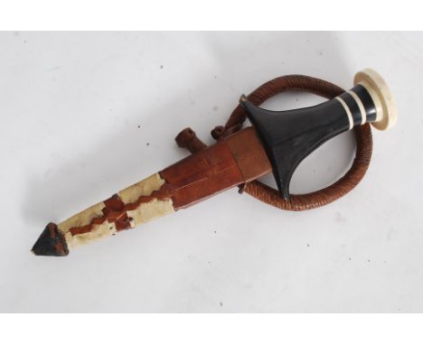 An African bone and lignum handled knife / dagger having the leather scabbard complete with arm band