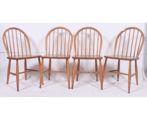 A set of 4 1930's Ercol beech and elm dining chairs. Raised on turned legs united by stretchers having panel seats with arche