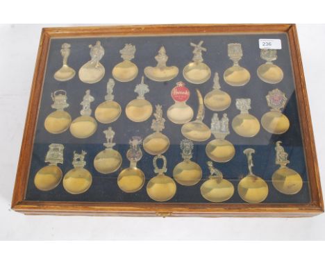 A large collection of vintage commemorative Caddy spoons, some within a glass display cabinet.