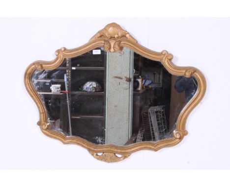 A 20th century gilt rococo wall mirror of shaped form with back panel and hanging string. 69cm x 91cm