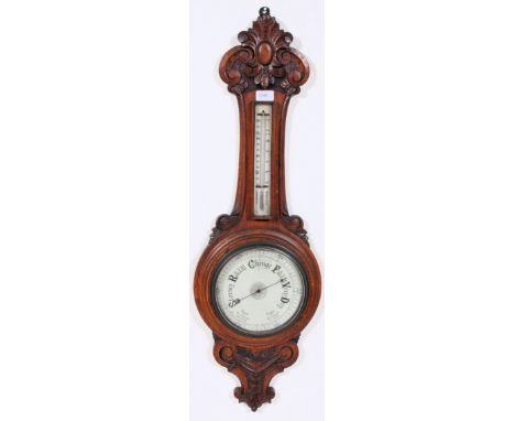 A 20th century carved oak wall hanging barometer and thermometer. Carved detail to the oak, decoration to face.