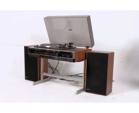 A retro 1970's Hitachi music centre / record player having wooden facia with smoked glass hood complete on the original stand