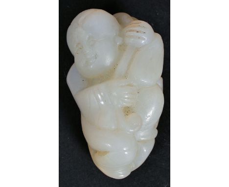 An early 20th century Chinese oriental Celadon Jade carved figure of a child, with Ruyi in hand, wrapped in traditional dress