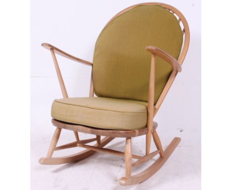 An Ercol beech and elm wood light tall back Windsor country rocking chair /  armchair with squab cushions being raised on tur