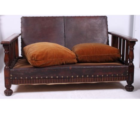 An early 20th century 1930's Shaker style leather and oak reclining sofa settee. The leather seat flanked by railed oak armre