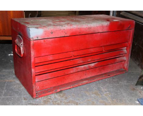 A vintage red metal industrial tool box.