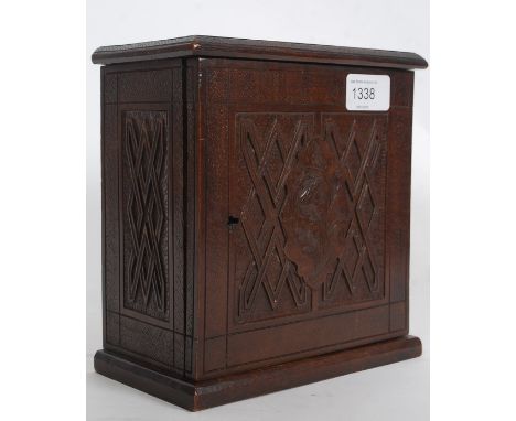 A Victorian carved walnut apprentice piece cabinet. The cabinet raised on plinth base having carved panel with geometric shap