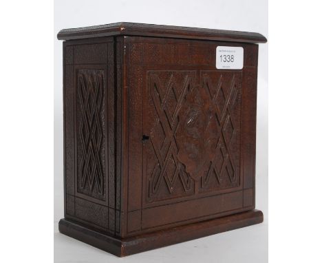 A Victorian carved walnut apprentice piece cabinet. The cabinet raised on plinth base having carved panel with geometric shap