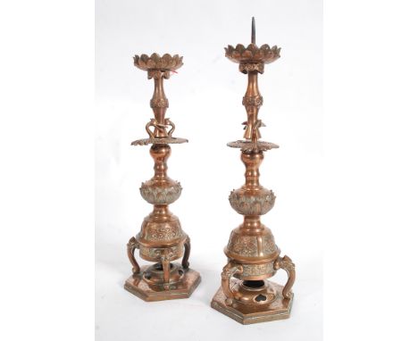 A pair of 19th century Japanese candlesticks of good size and form being raised on elephant tripod supports with shaped stems