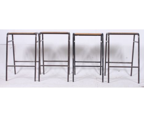 A set of 4 1950's stacking school / Industrial laboratory stools. The black metal frames with pierced wooden panel seats