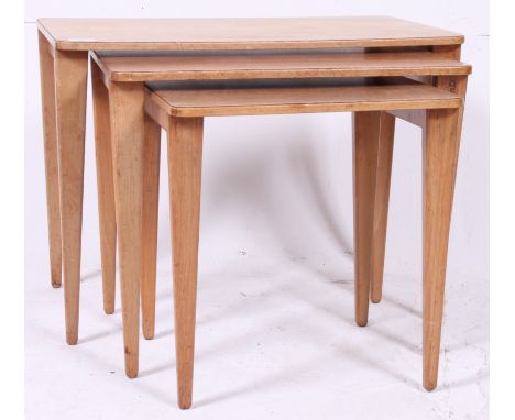 An original and rare Gordon Russell walnut graduating nest of tables raised on tapered supports with graduating tops above. G