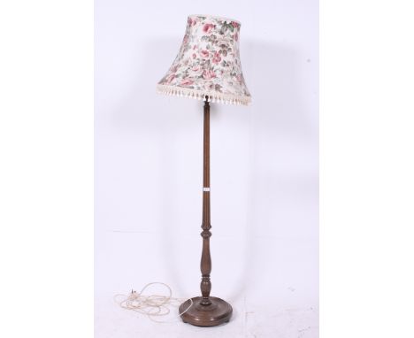 A good early 20th century mahogany standard lamp having circular terraced base with reeded stem, complete with shade.  H185cm