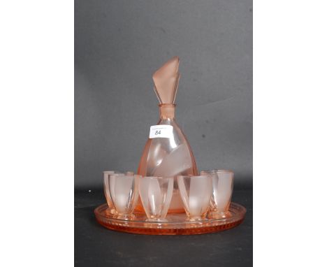 An art deco pink glass decanter along with six matching glasses and tray.