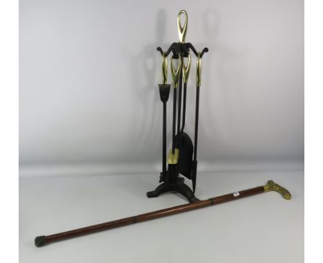 Cast iron and brass companion set plus a walking stick with brass eagle handle.
