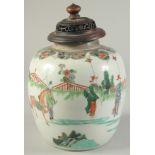 A CHINESE FAMILLE VERTE PORCELAIN JAR AND HARDWOOD COVER, finely decorated with a procession