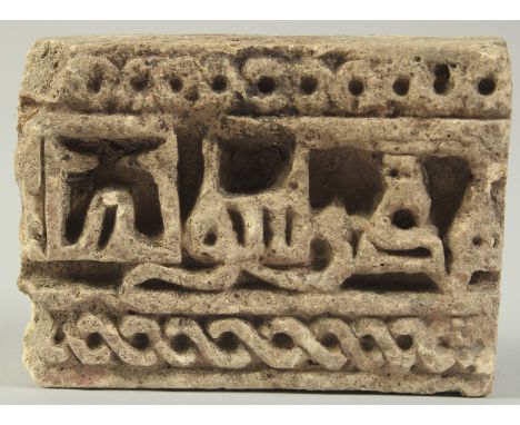 A FINE EARLY ISLAMIC POSSIBLY PERSIAN UNGLAZED POTTERY TILE FRAGMENT, with Kufic calligraphy, 12cm x 8.5cm, 3.5cm thick.