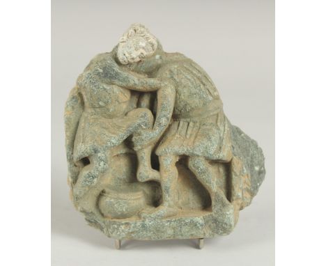 A RARE GANDHARA CARVED STONE TILE FRAGMENT, depicting two men wrestling, 15cm x 14cm.