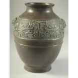 A CHINESE BRONZE VASE, with a band of archaic design and twin beast-head handles, 22cm high.