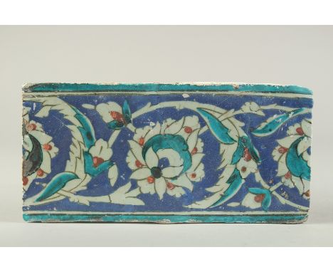 A FINE 16TH CENTURY OTTOMAN TURKISH IZNIK BORDER TILE, 25cm x 12.5cm.