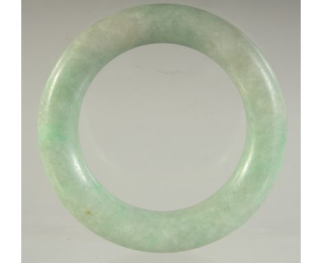 A SMALL ANTIQUE CHINESE JADEITE BANGLE, 6cm diameter.