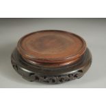 A SINGLE CHINESE CARVED HARDWOOD CIRCULAR STAND, with pierced base, the stand to house a base of