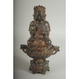 A CHINESE BRONZE SEATED DEITY LIDDED CENSER, the censer of lotus form, with traces of gilt