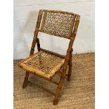 A folding vintage bamboo and wicker chair
