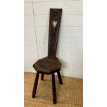 An oak spinning chair with floral back and seat on turned legs