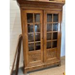 A large two door cabinet comprising of two glazed doors opening to five shelves (H225cm D45cm