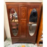 A mahogany and inlaid wardrobe comprising of two mirrored doors flanking an ornate central shield