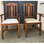 A pair of oak Arts and Crafts style arm chairs with drop in seals Circa 1905