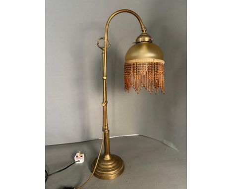 A 1930's style brass table lamp with tasselled shade