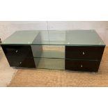 A glass media unit with drawers to ends (H54cm W150cm D53cm)