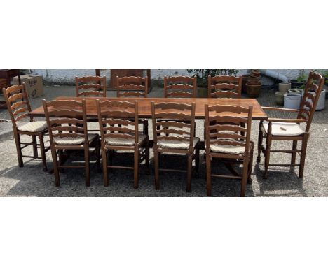 A large oak dining table with ten ladder back chairs (H73cm W243cm D90cm)