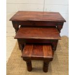 A nest of three hardwood tables with black metal studded detail